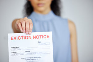 Cropped shot of an unrecognizable woman holding an eviction notice at home.